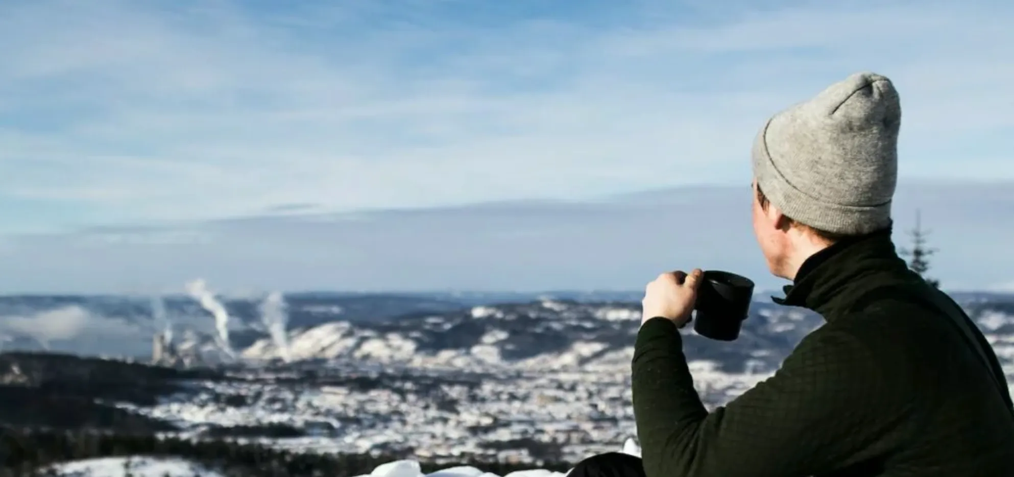Male sitting outside in winter drinking cup of tea